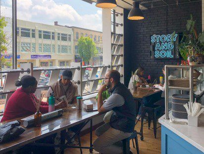 USEFULL and CET staff speak with a representative of Story and Soil about reusable containers