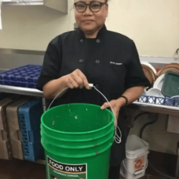 Back of house - extra bin Restaurant employee holding a bucket for scrap separation in BOH