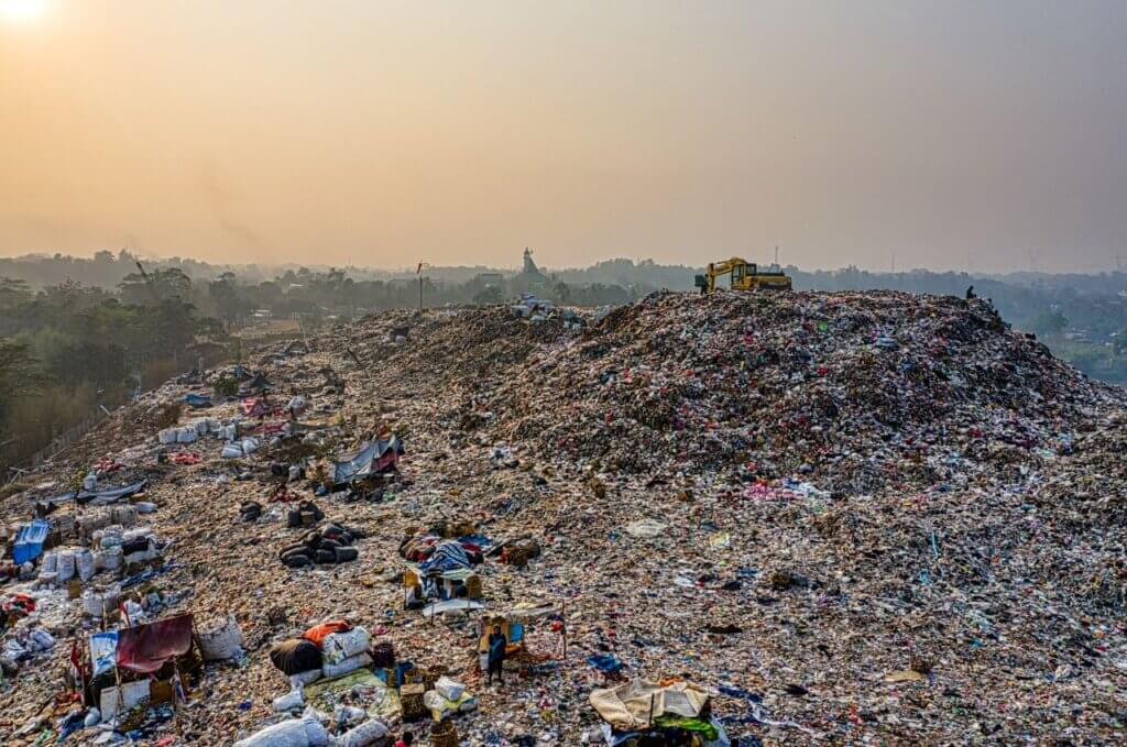 Aerial shot of a large landfill with garbage piles, showcasing waste management challenges.